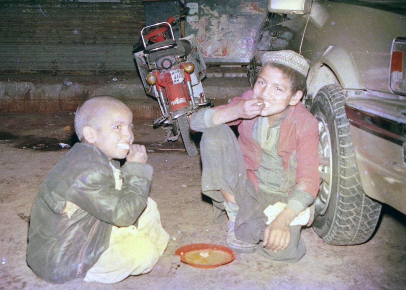 Two boys share a simple meal on the roadside, one of the many small moments recorded during the outreach. Two boys share a simple meal on the roadside, one of the many small moments recorded during the outreach.