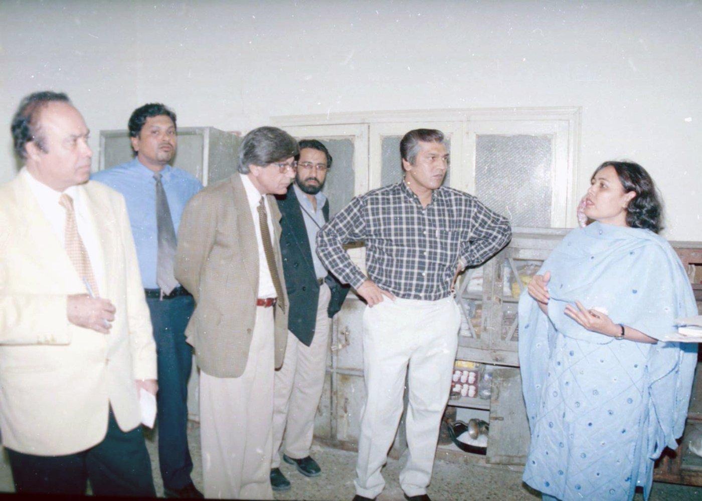 A staff member briefs the team on storage and supplies while members note down what they hear.