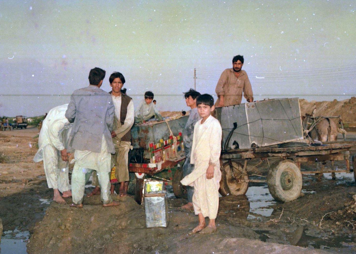 Residents fill tanks and tins from a water point, then load them onto a donkey cart. Residents fill tanks and tins from a water point, then load them onto a donkey cart.
