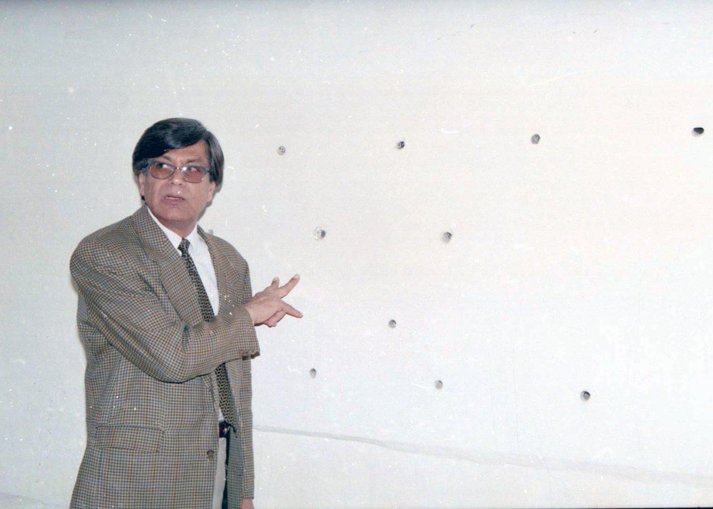 A team member points out marks on a wall as conditions of the building are documented for the record.