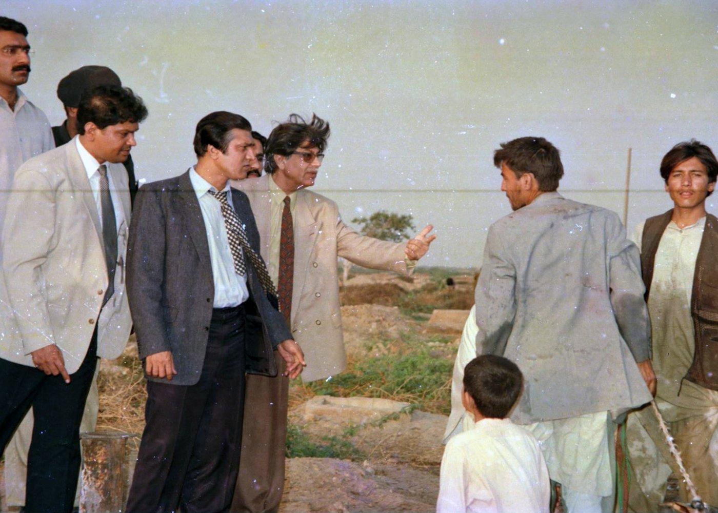 ICOHR representatives speak with residents at the edge of the settlement as the light begins to fade. ICOHR representatives speak with residents at the edge of the settlement as the light begins to fade.